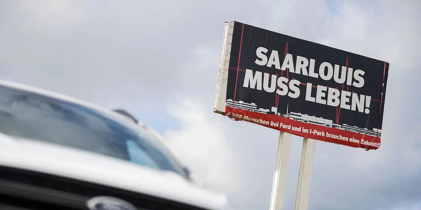 Protestschild vor einem Auto am Fordwerk Saarlouis - Foto Oliver Dietze dpa Archivbild.jpg